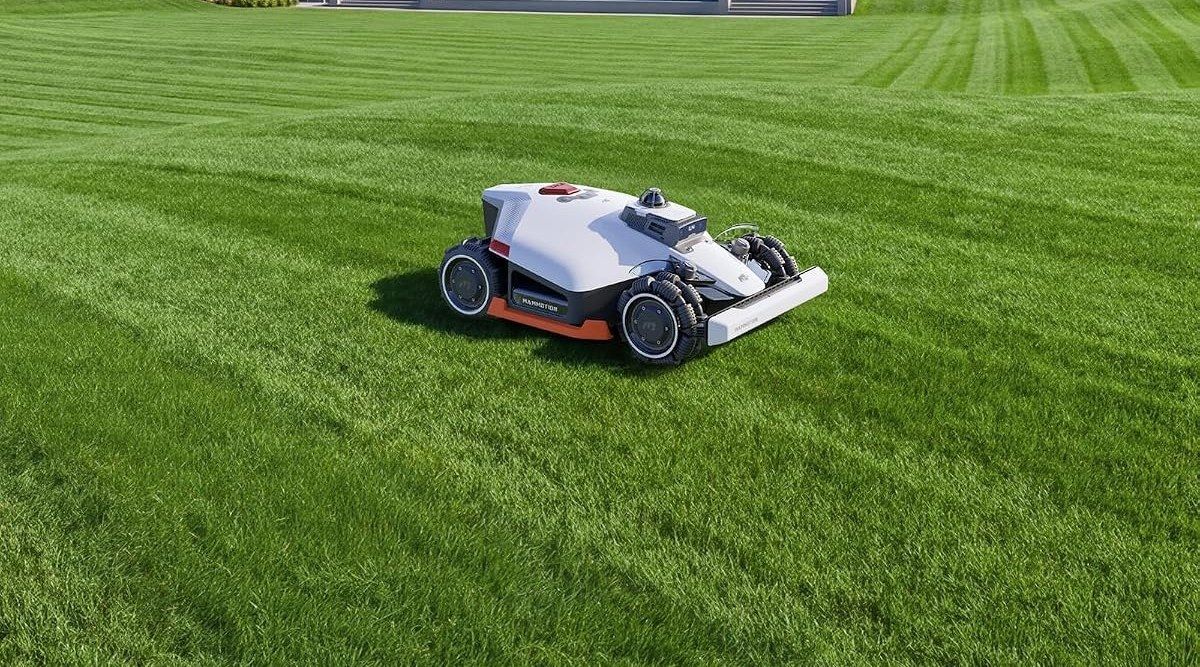 Weiß-schwarzer Allrad-Mähroboter mit orangefarbener Leiste, Omni-Rädern mit Querrollen und Sensoraufsatz auf einem großen, in Streifen gemähten Rasen, im Hintergrund eine breite Treppe