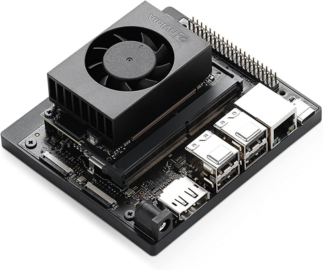 Schwarzes Jetson Orin Nano Developer Kit schräg von oben mit Lüfter-Kühlkörper, 40-poliger Stiftleiste, vier USB-A-Buchsen, Ethernet- und DisplayPort-Anschluss.