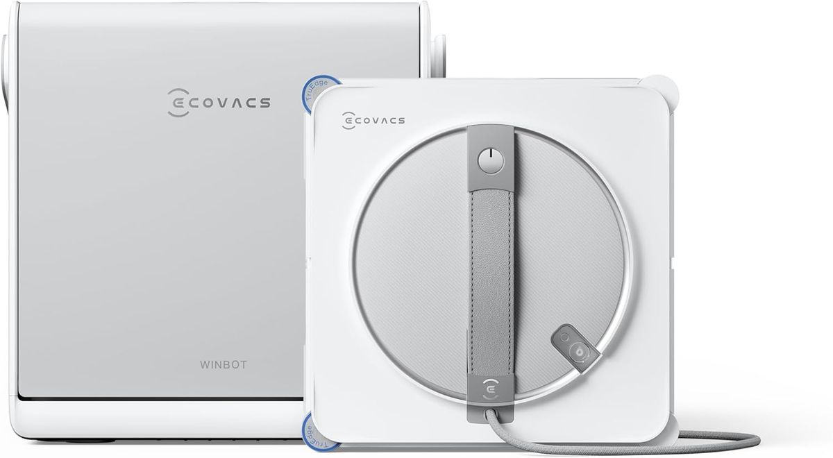 Weißer ECOVACS WINBOT W2S OMNI Fensterputzroboter mit blauen TruEdge-Eckschrubbern vor seiner silbergrauen Multifunktionsstation.