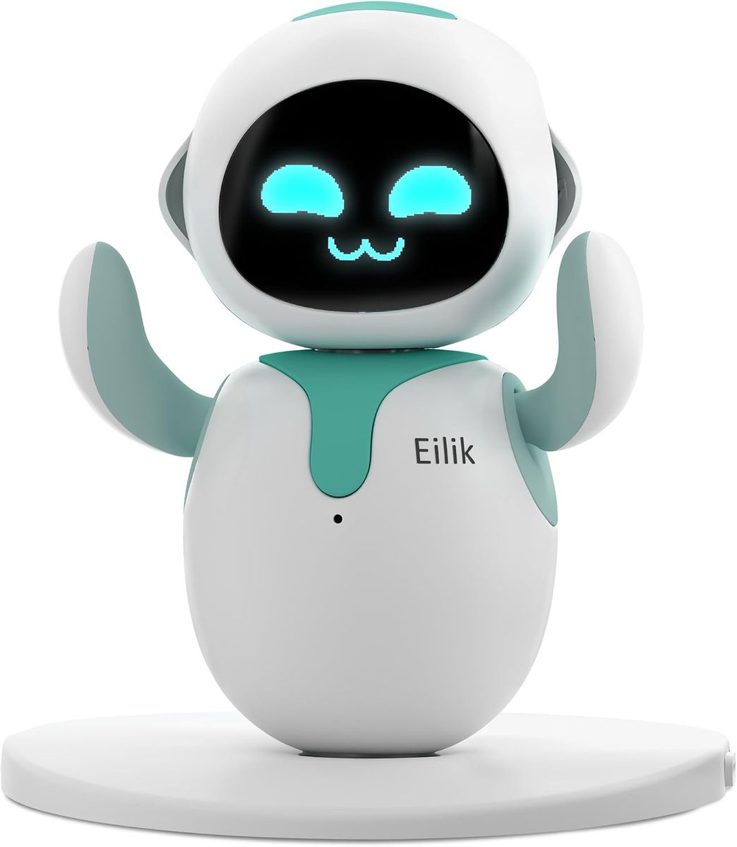Weiß-türkiser Eilik-Roboter mit erhobenen Armen und lächelndem Pixelgesicht auf dem Display, stehend auf seinem runden weißen Standfuß.