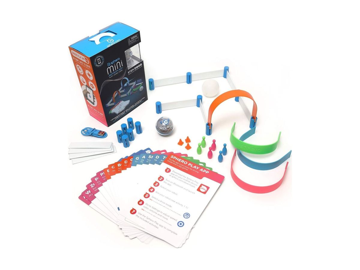 Sphero Mini Activity Kit mit Verpackung, transparenter Roboterkugel, weißer Abdeckung, bunten Bögen, Bande-Elementen, Pins, Hütchen, Ladekabel und Aktivitätskarten.