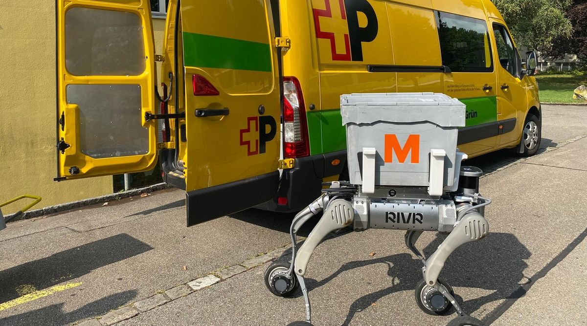 Vierbeiniger Lieferroboter von RIVR mit grauer Migros-Box auf dem Rücken vor einem gelben Lieferwagen der Schweizerischen Post