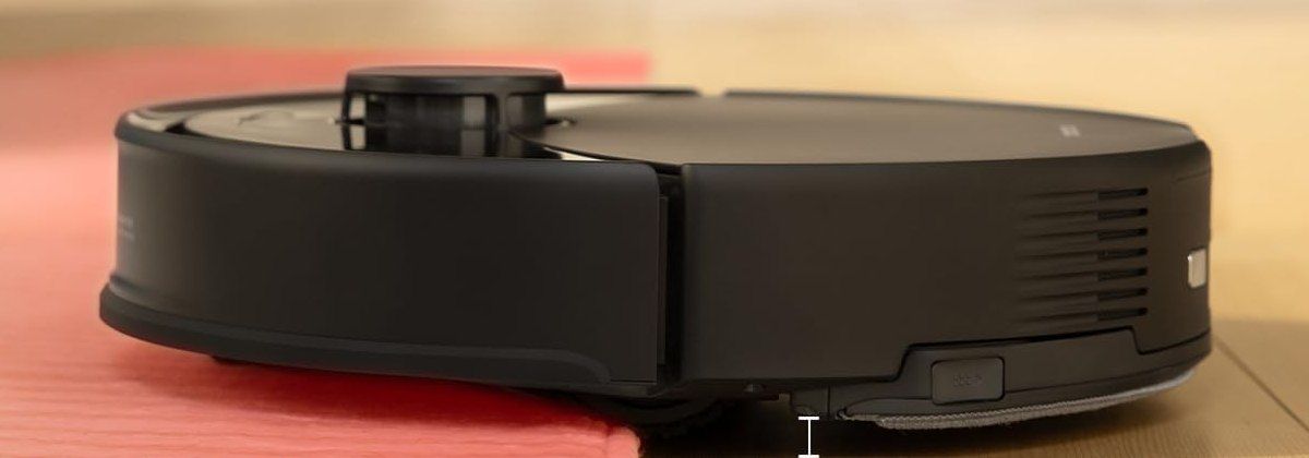 Seitenansicht des schwarzen roborock Q10 X5 beim Auffahren auf einen roten Teppich.