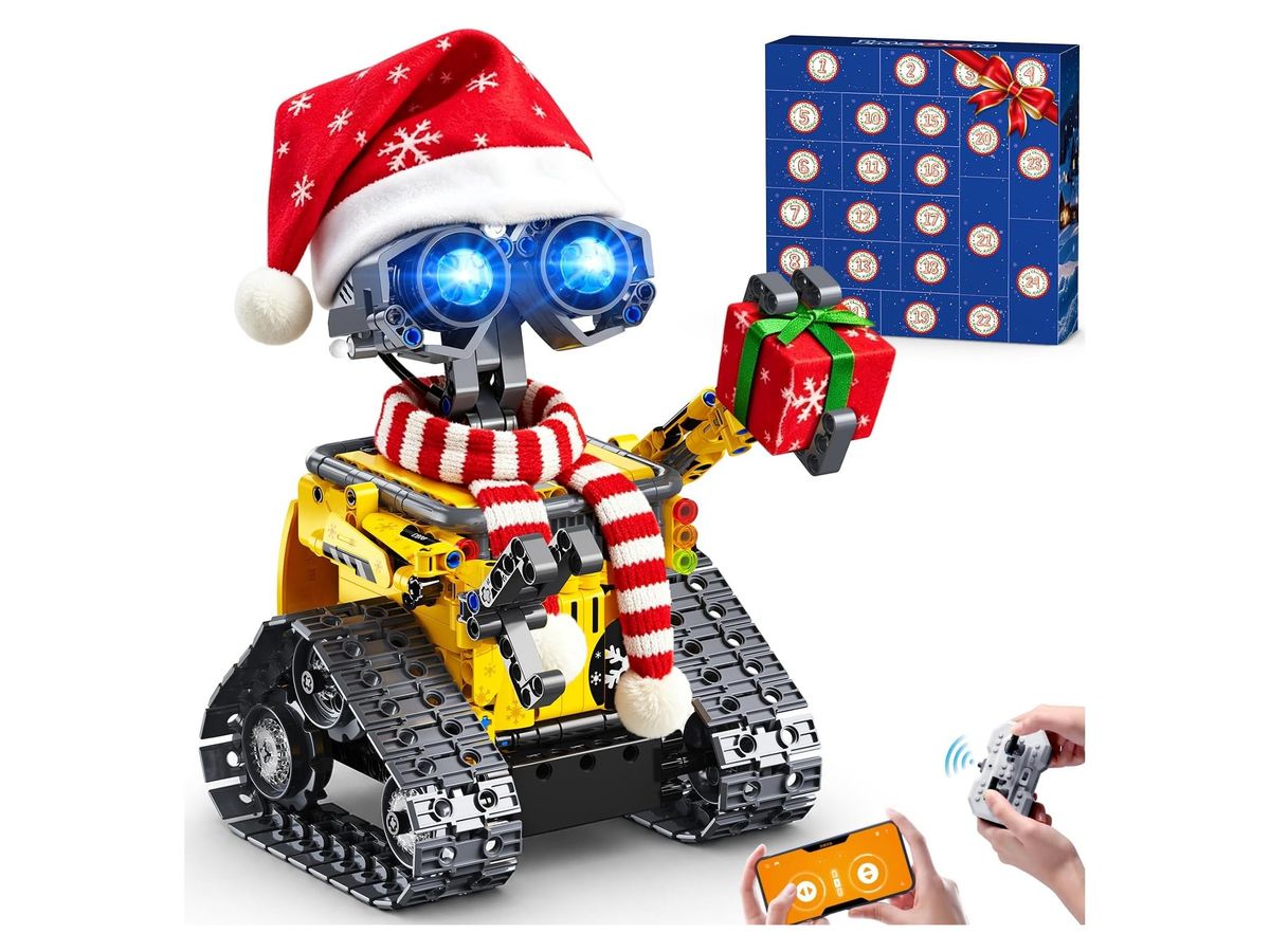 Gelber Kettenroboter aus Klemmbausteinen mit blau leuchtenden Augen, roter Weihnachtsmütze und rot-weißem Schal hält ein rotes Geschenk, dahinter der blaue Adventskalender mit nummerierten Fächern, unten Hände mit App und Fernbedienung.