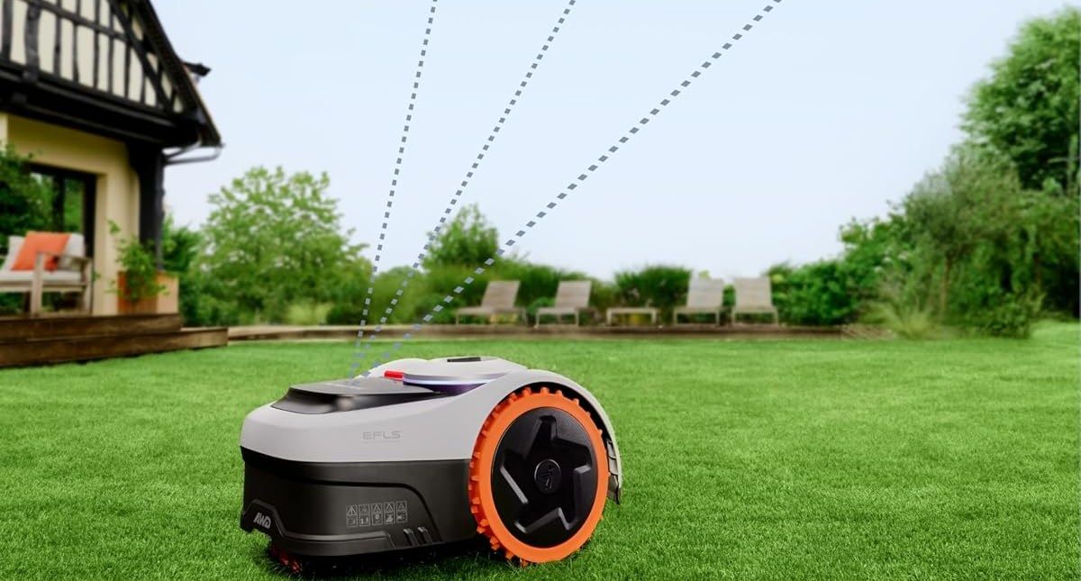 Ein Navimow-i2-AWD-Mähroboter mit orangefarbenen Rädern steht auf einem Rasen vor einem Fachwerkhaus, gestrichelte Linien deuten die Satellitenverbindung an.