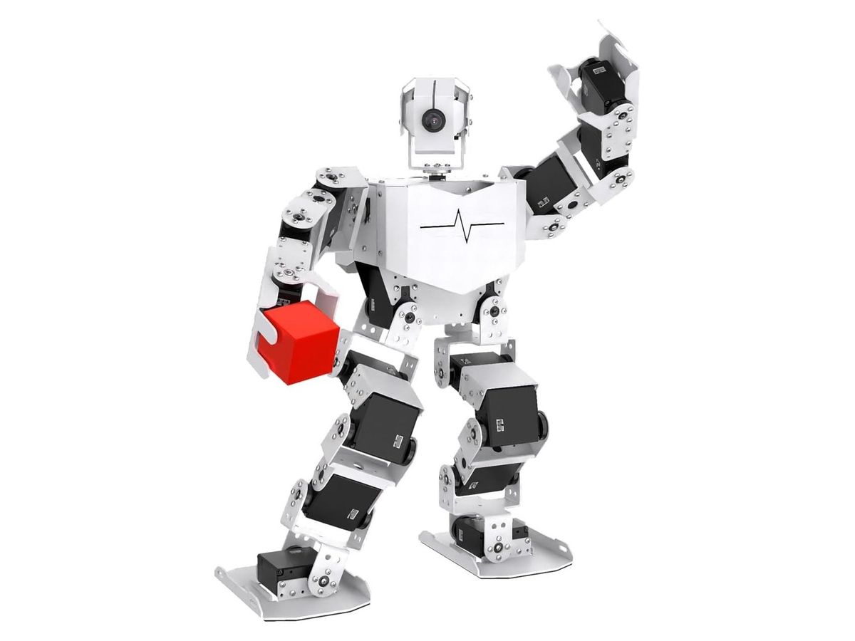 Weiß-schwarzer Humanoid-Roboter hebt den linken Arm und hält mit der rechten Greifhand einen roten Würfel, freigestellt auf weißem Grund.
