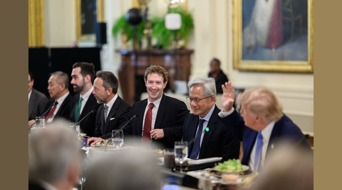 Mark Zuckerberg in dunklem Anzug mit roter Krawatte lacht an einer festlich gedeckten Tafel, rechts neben ihm Jensen Huang mit Brille, ganz rechts angeschnitten Donald Trump mit erhobener Hand, links weitere Männer in Anzügen, im Vordergrund unscharfe Hinterköpfe, hinten ein Kamin mit Grünpflanzen und ein Gemälde