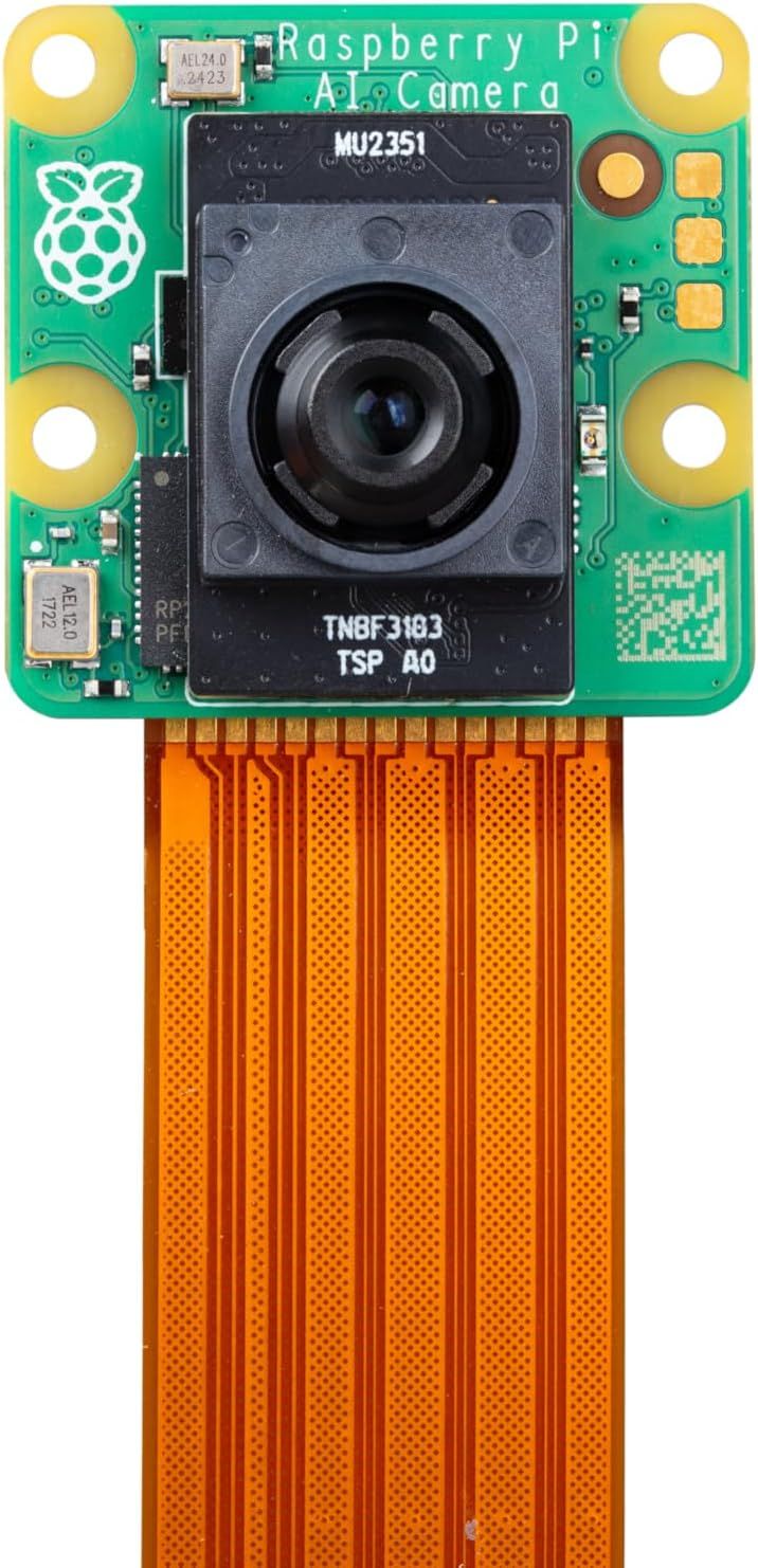 Grüne Platine mit Aufdruck „Raspberry Pi AI Camera“, schwarzem IMX500-Kameramodul mit Objektiv und orangefarbenem Flachbandkabel.