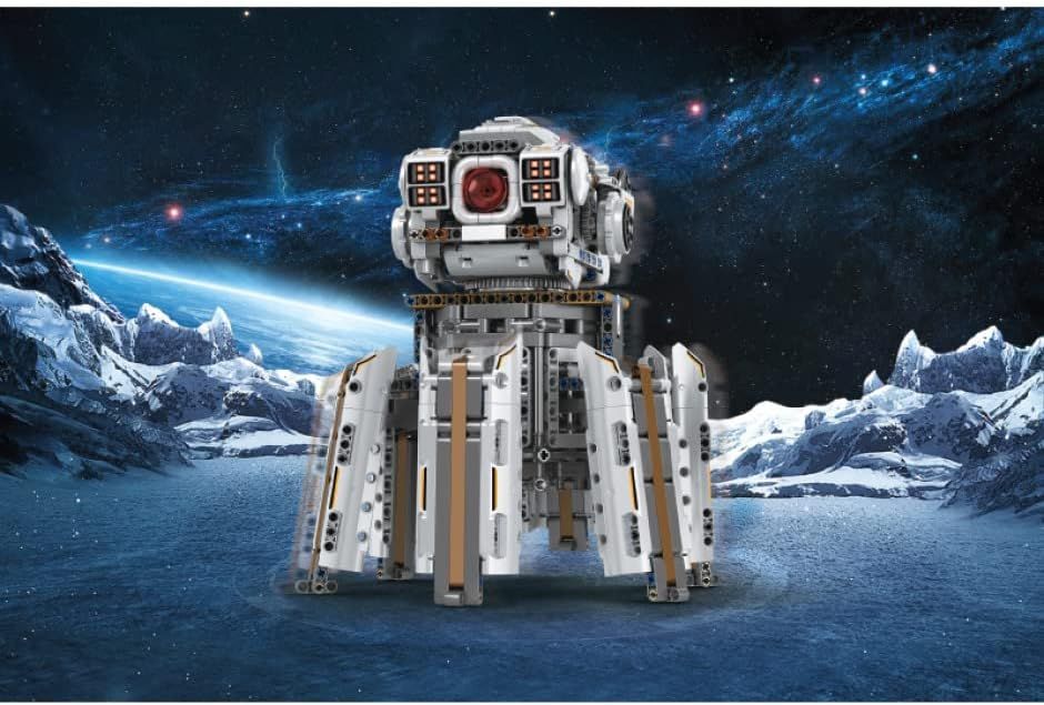 Weiß-grauer sechsbeiniger Klemmbaustein-Roboter mit rundem Kopf, rotem Auge und Pixelaugen-Panels auf einer verschneiten Eisfläche vor einem Sternenhimmel.