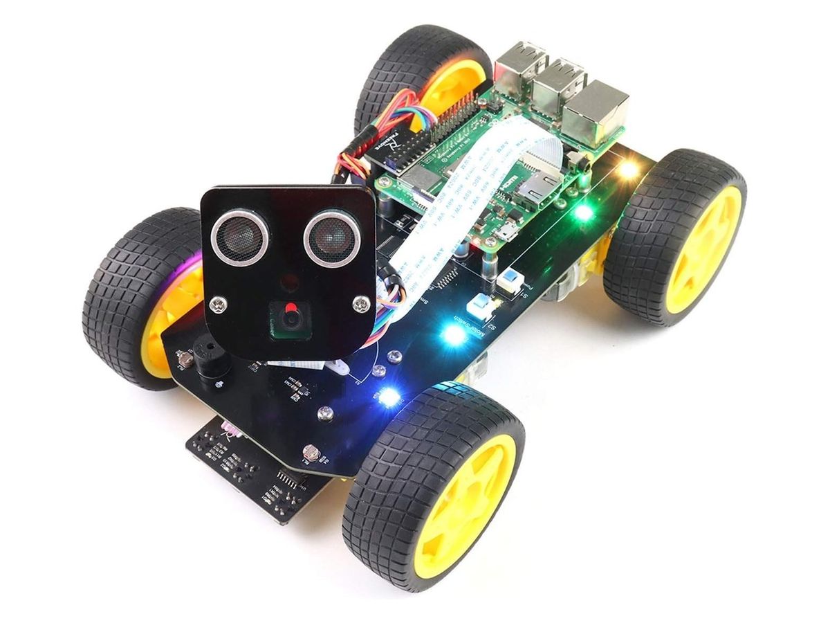 Vierrädriges Roboterauto mit gelben Felgen, schwarzer Platine mit bunten LEDs, Raspberry Pi und einem Kopf mit Ultraschallsensor und Kamera.
