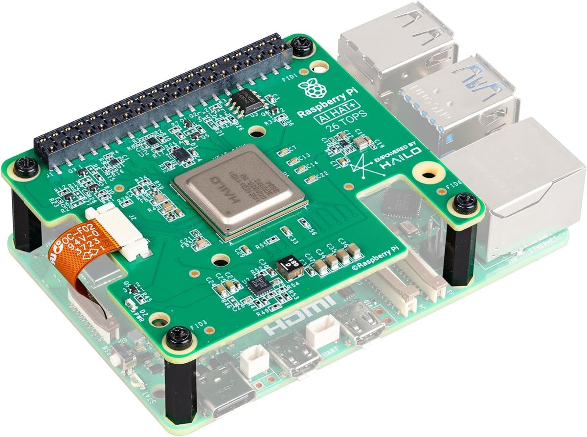 AI HAT+ mit Aufdruck 26 TOPS, mit schwarzen Abstandshaltern auf einem halbtransparent dargestellten Raspberry Pi 5 montiert.