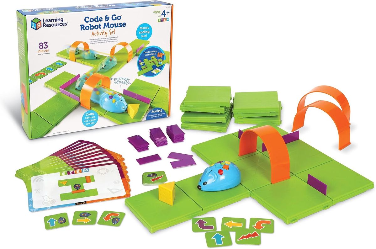 Code & Go Robotermaus Activity Set: blaue Maus auf grünen Rasterplatten, dazu Tunnel, Wände, ein Käsestück und ein Stapel Programmierkarten