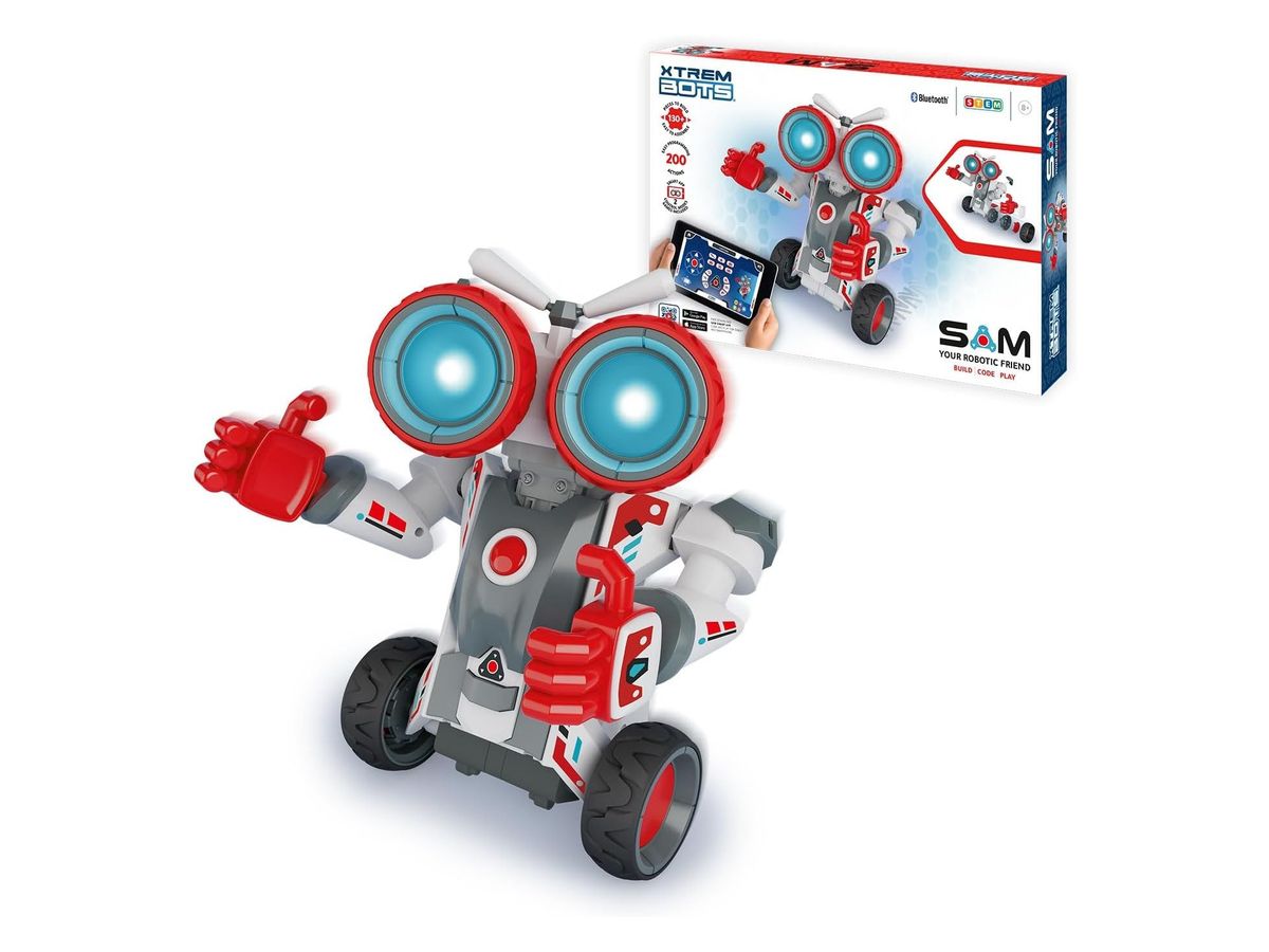 Fertig gebauter Roboter Sam mit großen leuchtenden Augen und roten Daumen-hoch-Händen vor seiner Verpackung
